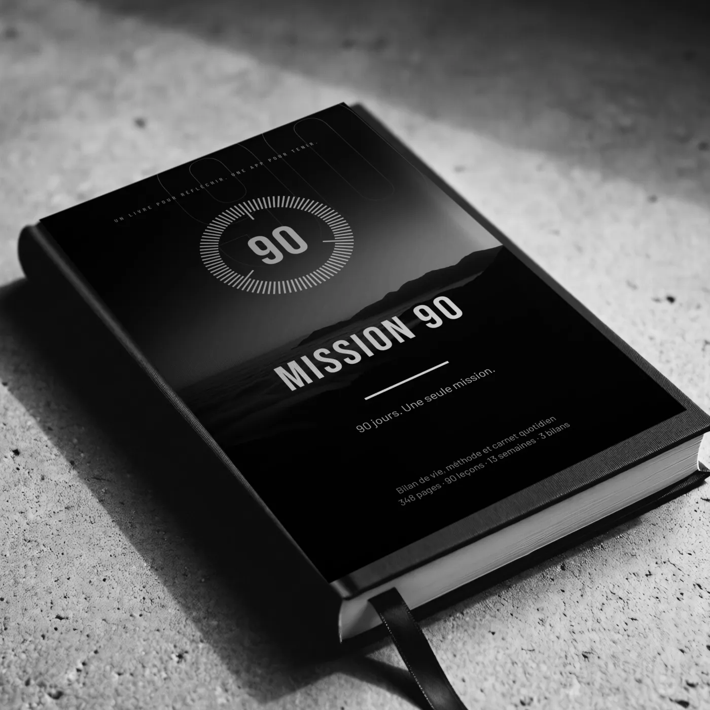 Le livre Mission 90, relié, posé sur du béton.